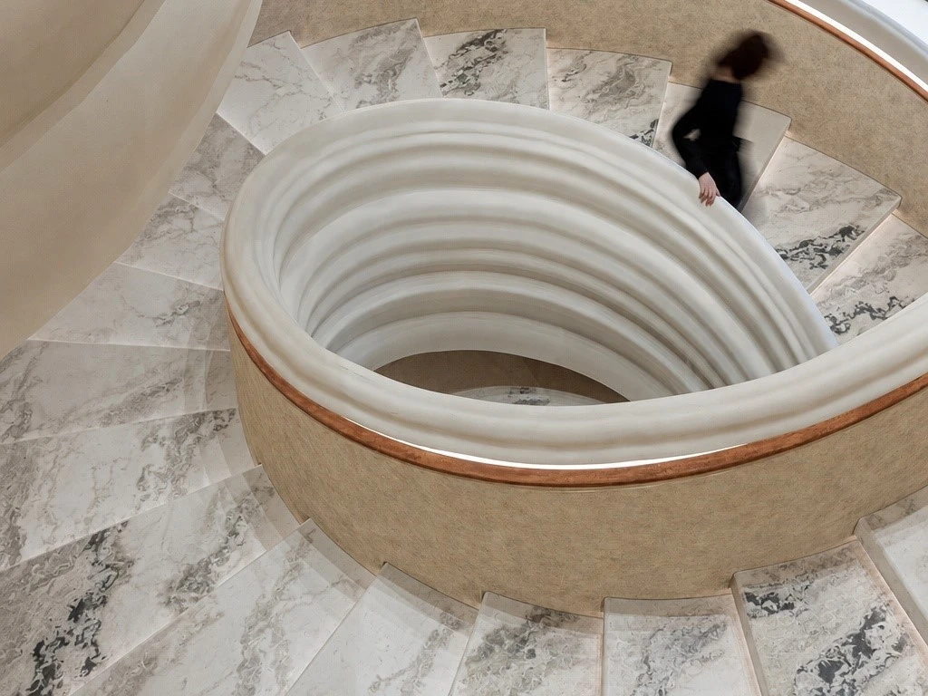 Oyster White Marble stair treads installed on a curved staircase with contrasting dark grey veining Oyster White Marble stair treads installed on a curved staircase with contrasting dark grey veining